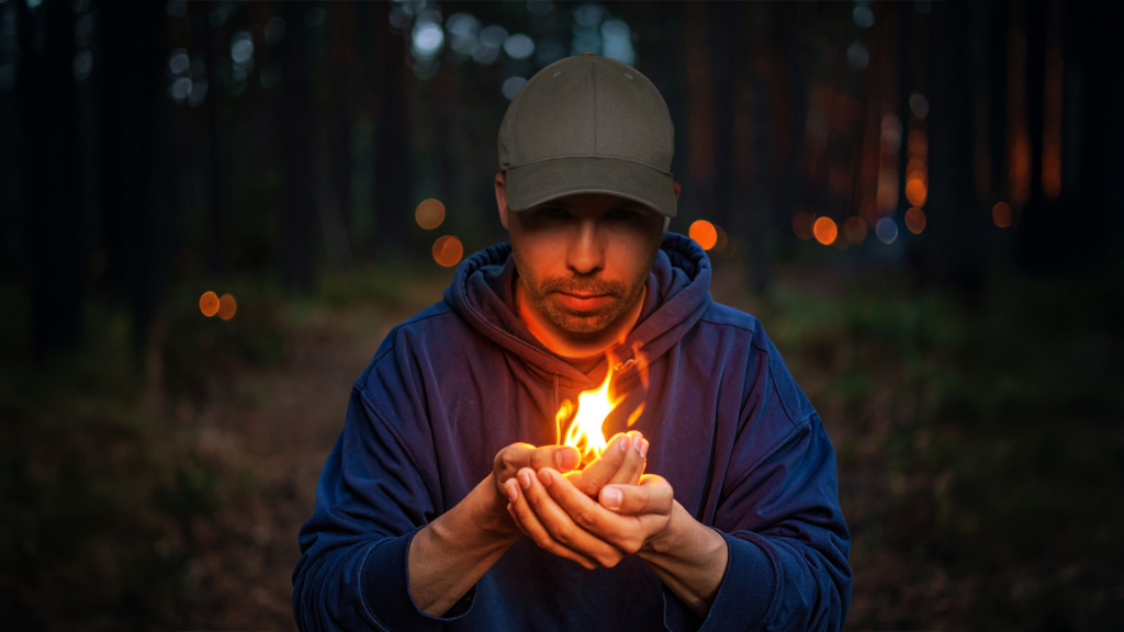 Jones Häkkinen pitelee liekkiä kädessään symboloiden keskustelun kipinää Nuotiopiiritapahtumassa bannerikuva