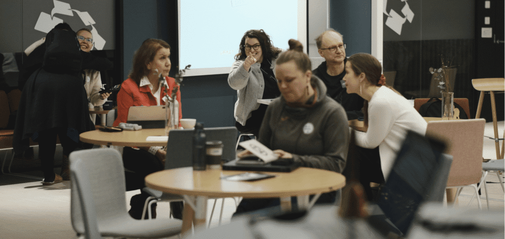 Ihmisiä osallistumassa tapahtumaan Crazy Townin yhteisöllisessä työtilassa. Coworking-ympäristö tarjoaa verkostoitumista yksinyrittäjille ja tiimeille.