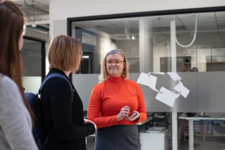 Ihmiset työskentelevät ja keskustelevat coworking-yhteisössä osana etätyön arkea