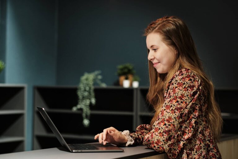 Mitä toimiston vuokraus maksaa vuotena 2026 yksinyrittäjälle, iloinen nainen selaa tietokonetta coworking-tiloissa